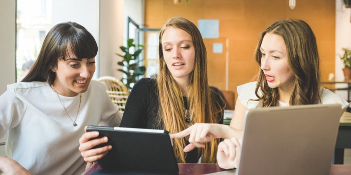 Three women indoor using computer business multitasking